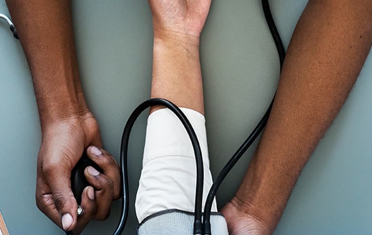 A clinician taking a patient’s blood pressure during a check-up